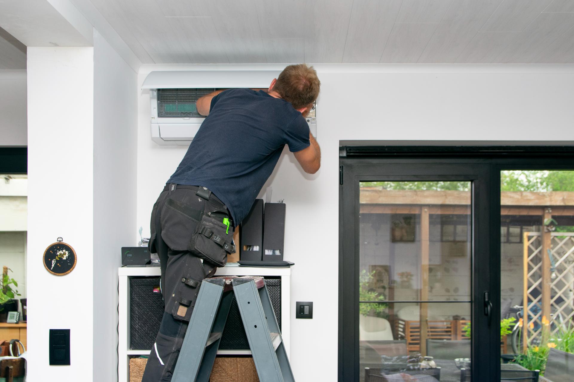 Technieker Werkt Aan Airco Unit Binnen